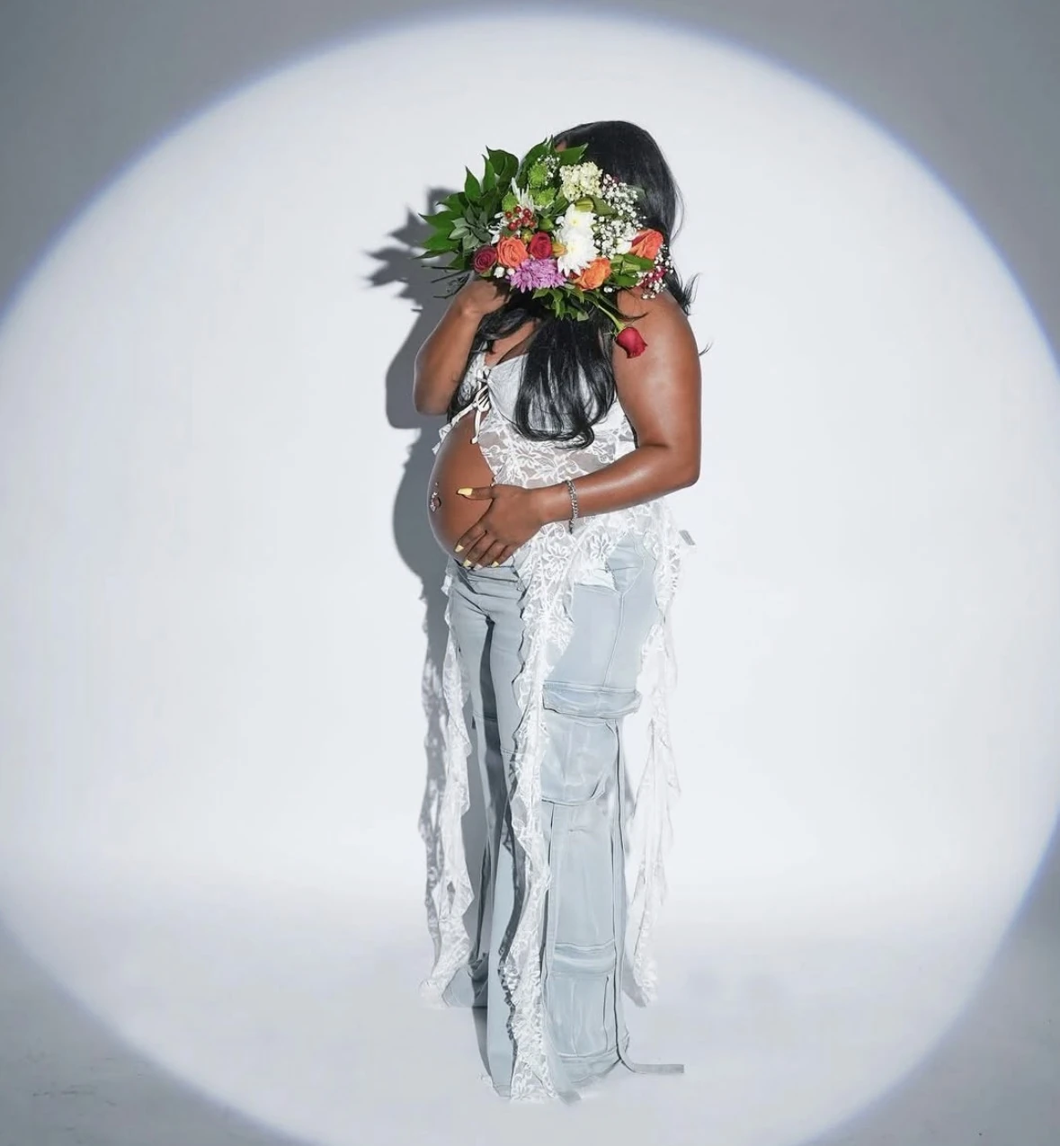 Editorial Houston maternity portrait with flowers and a studio spotlight