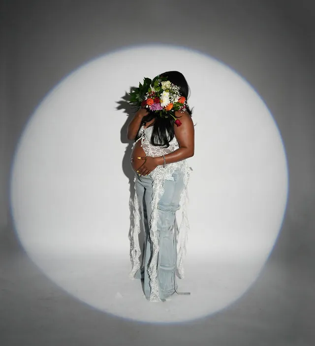 Creative maternity portrait with flowers and spotlight